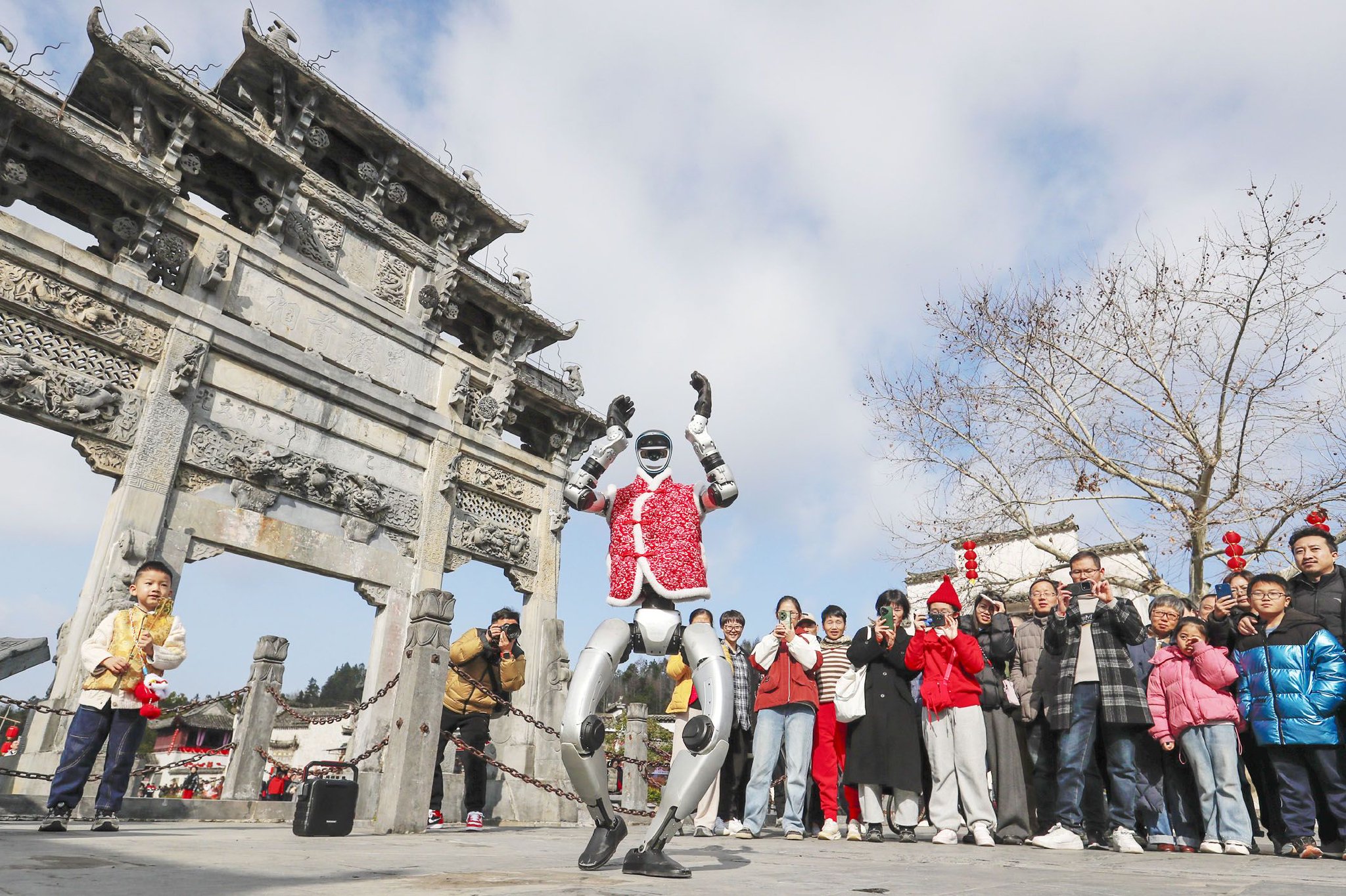 2月18日，游客在安徽省黟县西递古村观看机器人表演。新华社发（施亚磊　摄）