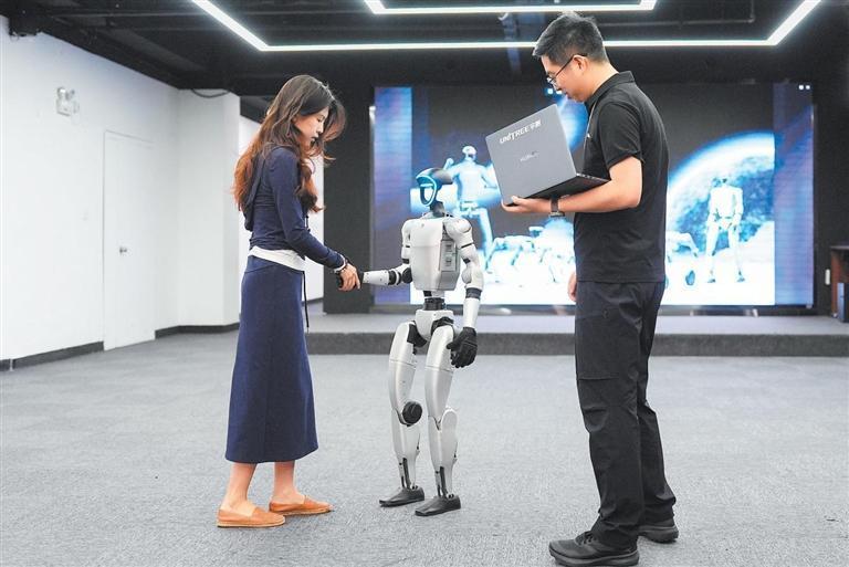 在机器人公司杭州宇树科技展厅内，宇树人形机器人G1展示握手动作。新华社发