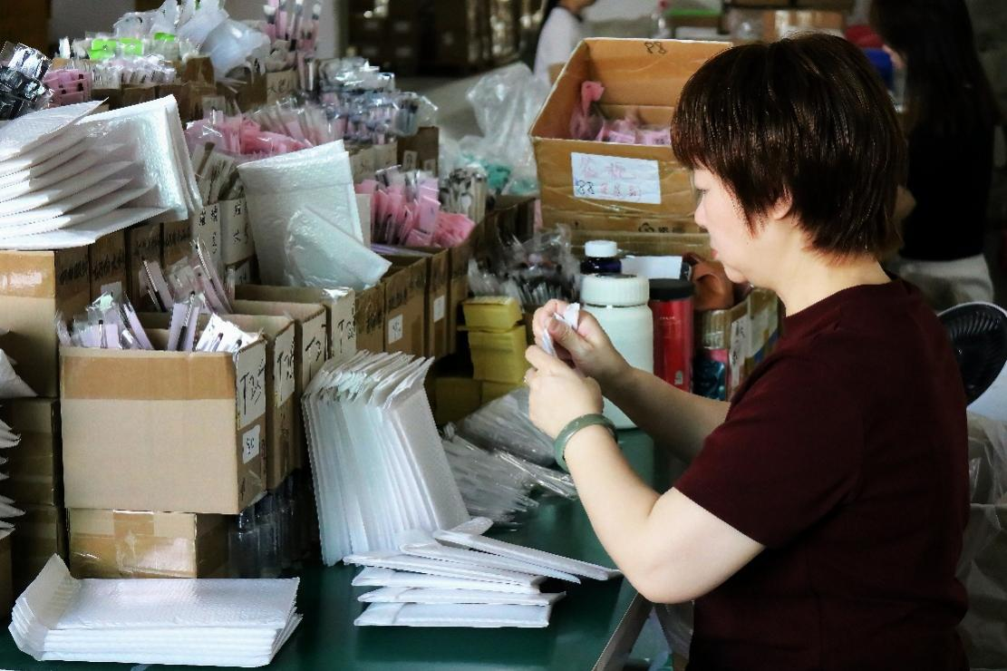 仓库内，工作人员按照订单进行产品分装，保障货品高效发出。陈以昀|摄