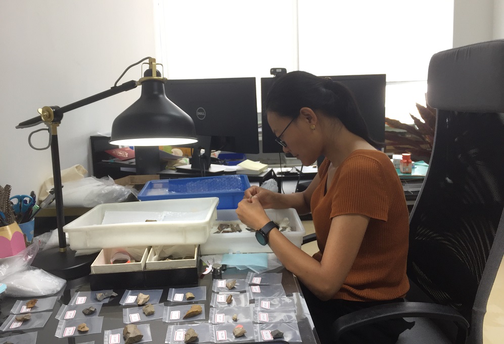 杨石霞在办公室看沉默的“破石头”，偶尔对着石头自言自语。受访者供图