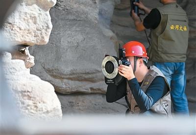 云冈研究院工作人员在云冈石窟进行数字化信息采集。新华社记者 杨晨光摄