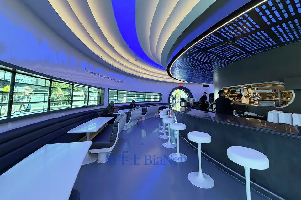 但店内只零星坐着几位食客，或坐在弧形长吧台，或身处灰白配色的复古未来主义卡座里，品尝着炸鸡三明治等美式简餐。