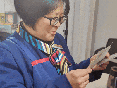 保洁大姐开心地翻阅照片