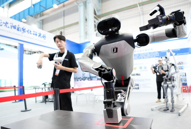 图：机器人工程师在调试具身智能操作系统 来源：新华社