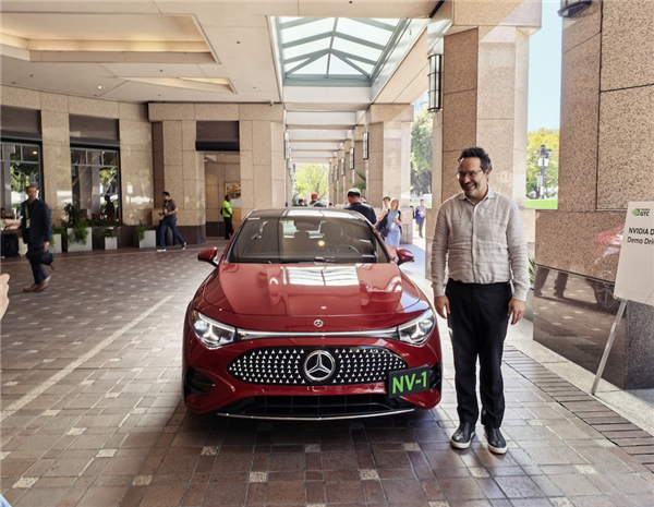英伟达汽车业务 VP Ali Kani 在试驾车前拍照|图片来源：极客公园