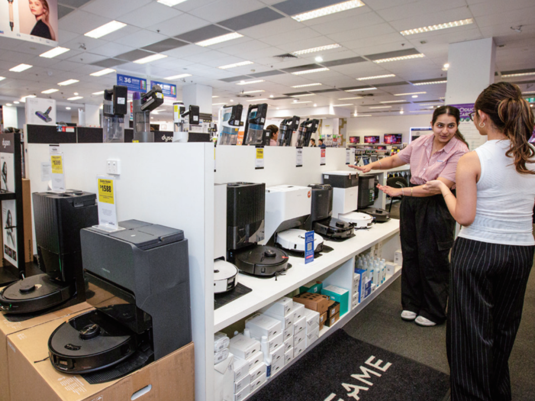 2025年10月13日，在澳大利亚悉尼市中心一家电器市集内，伴计向主顾先容中国品牌扫地机器东说念主      图/新华