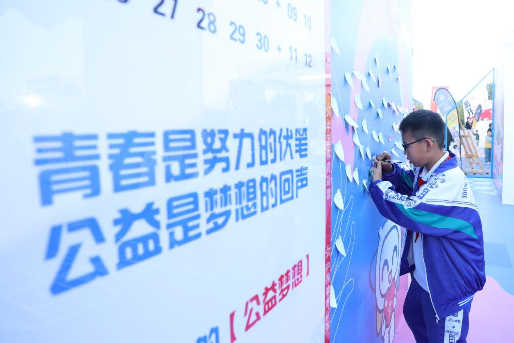2025年5月30日，在中卫市市政广场的中国体育彩票公益展区，一名学生写下公益寄语。