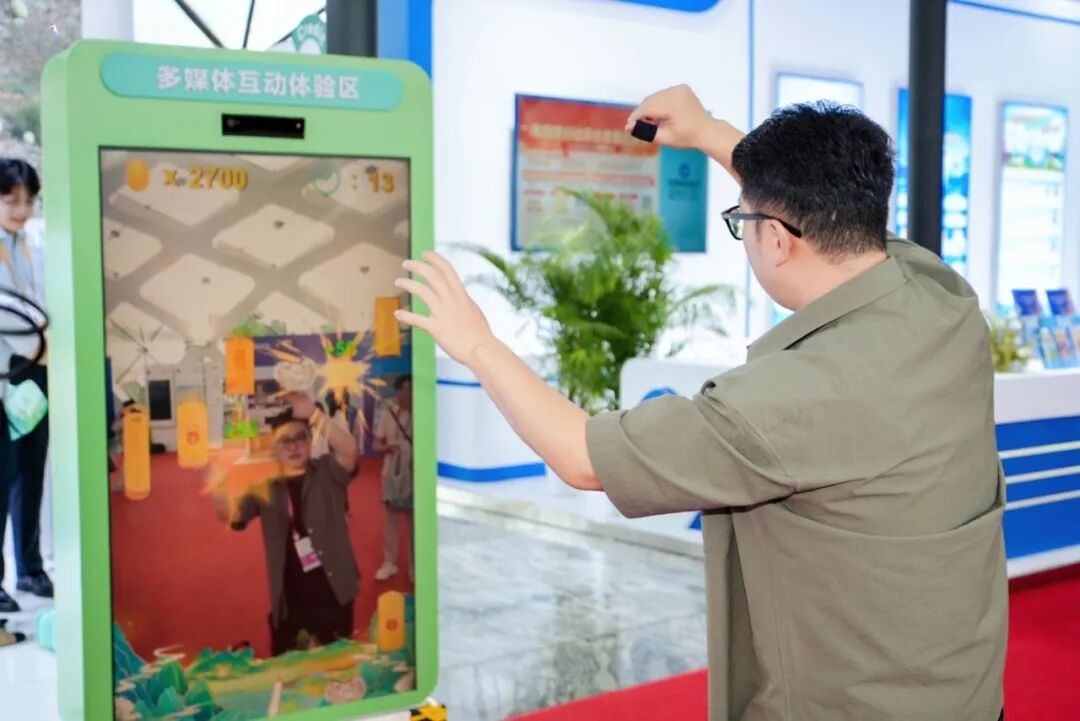▲旅客在多媒体互动区体验体感游戏。