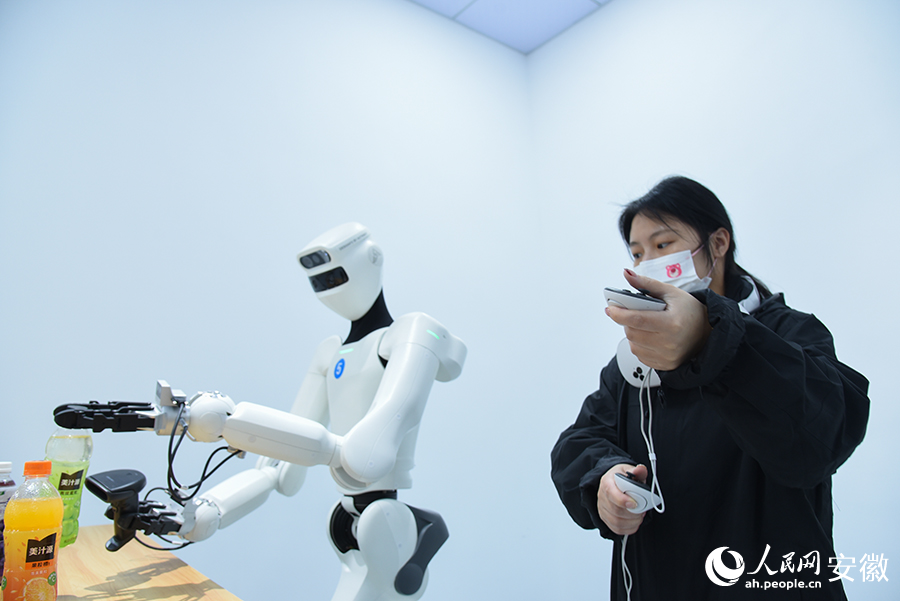 具身机器人正在训练师的操控下，反复训练动作。人民网记者 李希蒙摄