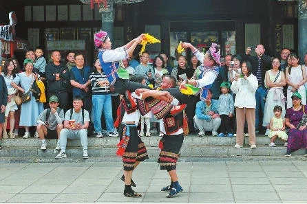 建水县“五一”假期推出系列文化主题活动。图为游客在朱家花园景区内观赏烟盒舞展演。记者 陈飞 摄