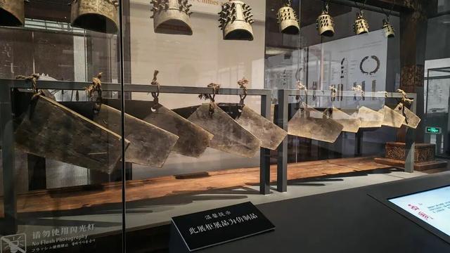此图为仿制品编钟、石磬展柜，并已标牌向游客说明。