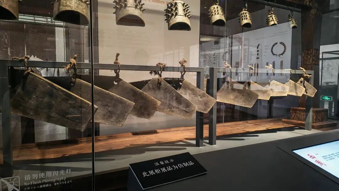 注明：此图为仿制品编钟、石磬展柜，并已标牌向游客说明