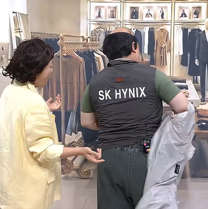 在韩国恶搞节目中，一名身穿印有SK海力士字样工作服的员工在商店里炫耀（图片来源：视频截图）