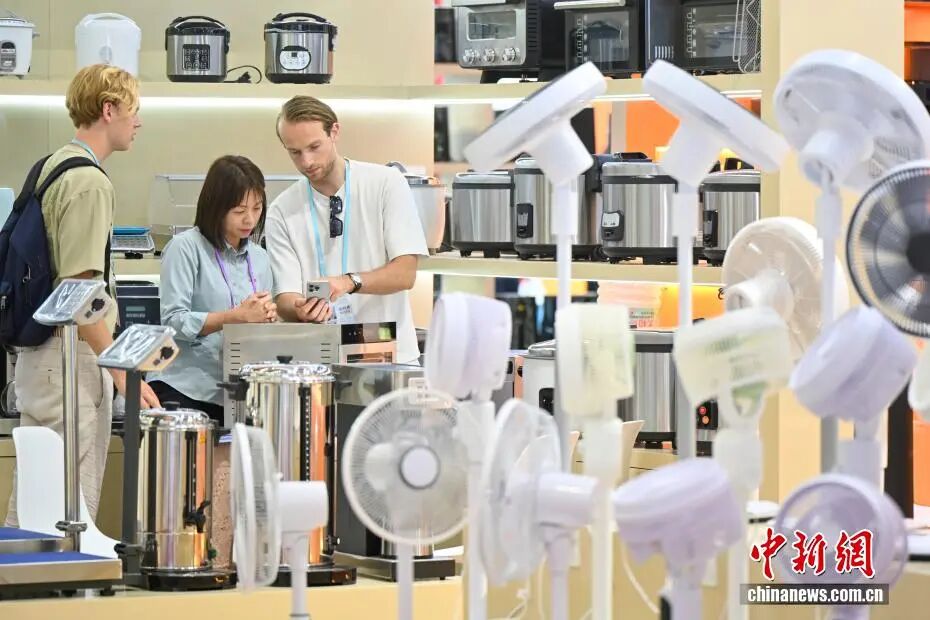 图为第139届中国进出口商品交易会上，境外采购商与家电参展商（中）洽谈。中新社记者 陈骥旻 摄