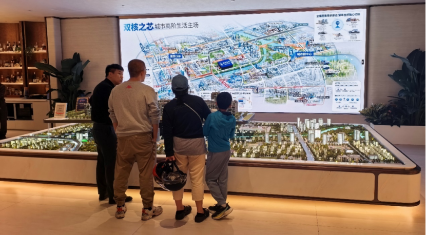 （北京通州区某老项目售楼处内听讲解的看房客户 张达/摄）