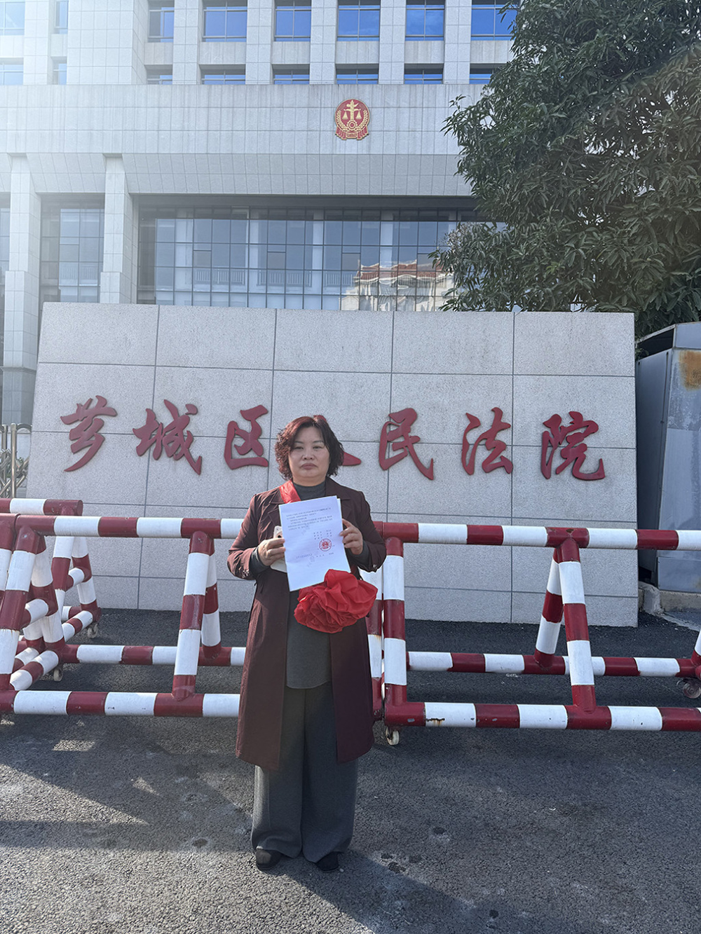 芗城区法院门口，林惠荣手持无罪判决书。王殿学 &nbsp;资料图