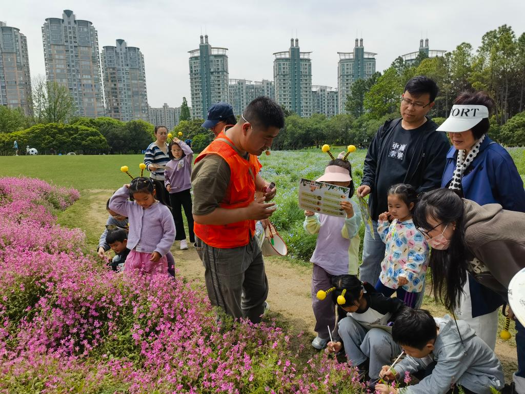 5月4日,亲子家庭来到上海世纪公园体验为花卉人工授粉。新华社记者 陈爱平 摄
