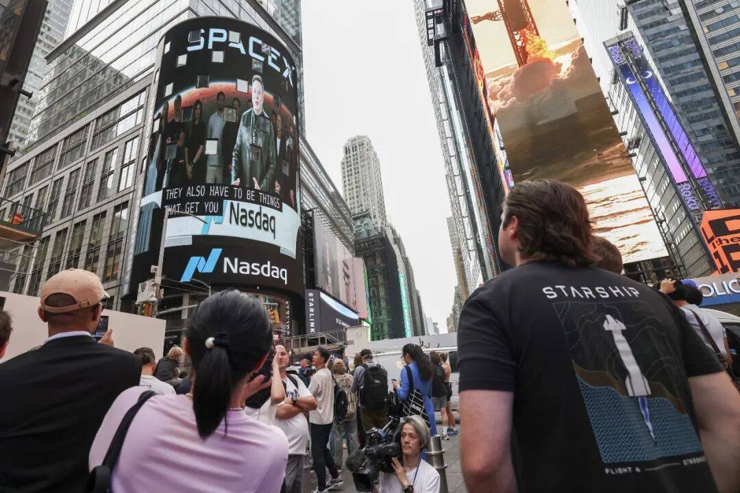 人们通过纽约时报广场大屏幕观看马斯克远程敲钟。图/视觉中国