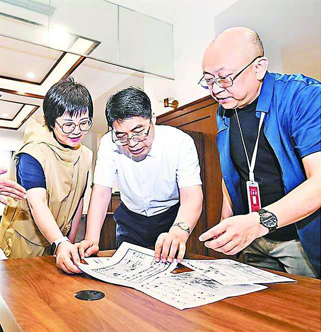 6月13日，重庆市档案馆，朱容瑢（左）查看80多年前关于奶奶的相关档案。