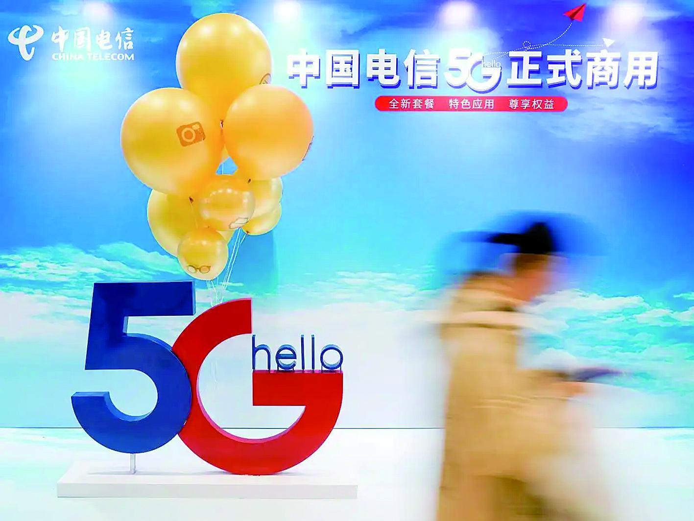 一名消费者走过5G的广告展板