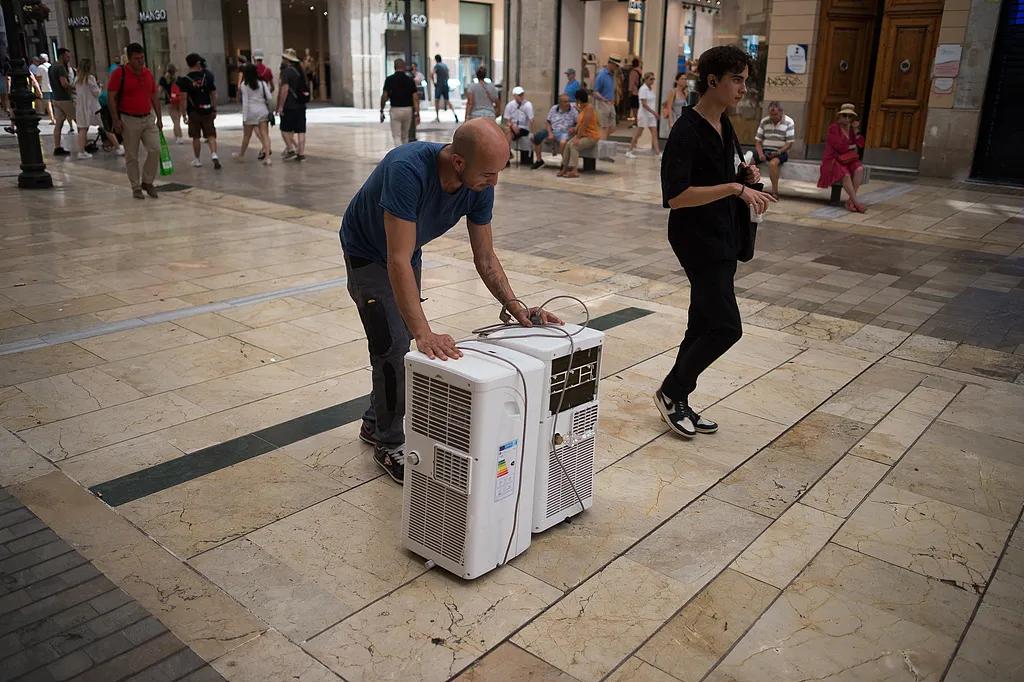 6月27日，欧洲多地气温超过40摄氏度。图为西班牙一名男子在搬运空调。（视觉中国）