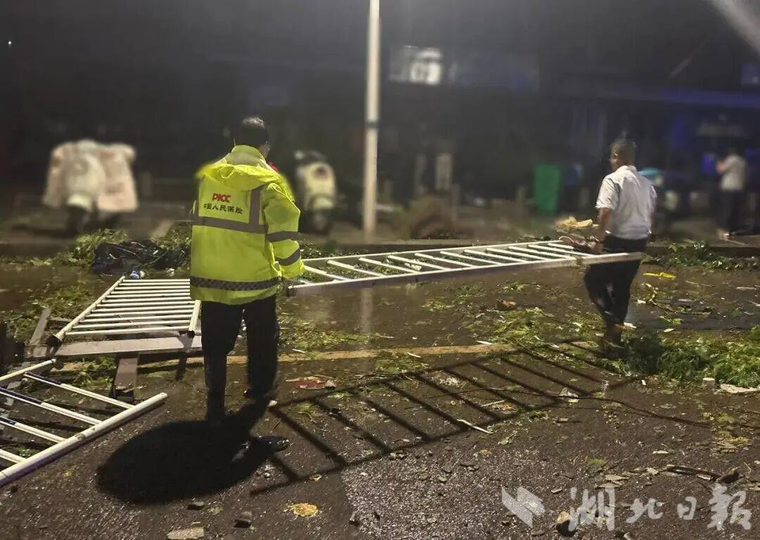 在鄂州市，理赔人员搬运清理被大风吹倒的马路护栏。人保财险湖北省分公司 供图