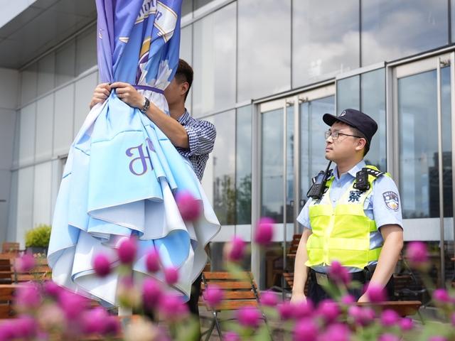 杨浦民警正督促商户扎紧遮阳伞。杨浦公安分局供图