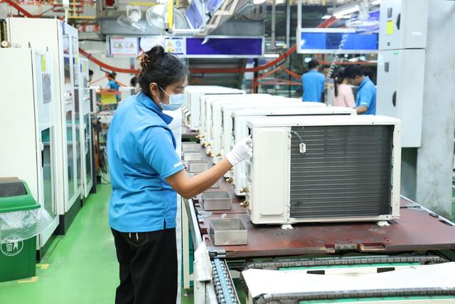 7月8日，在位于泰国春武里府的美的泰国工厂，工人为测试完成的空调贴铭牌。新华社记者孙玮彤摄