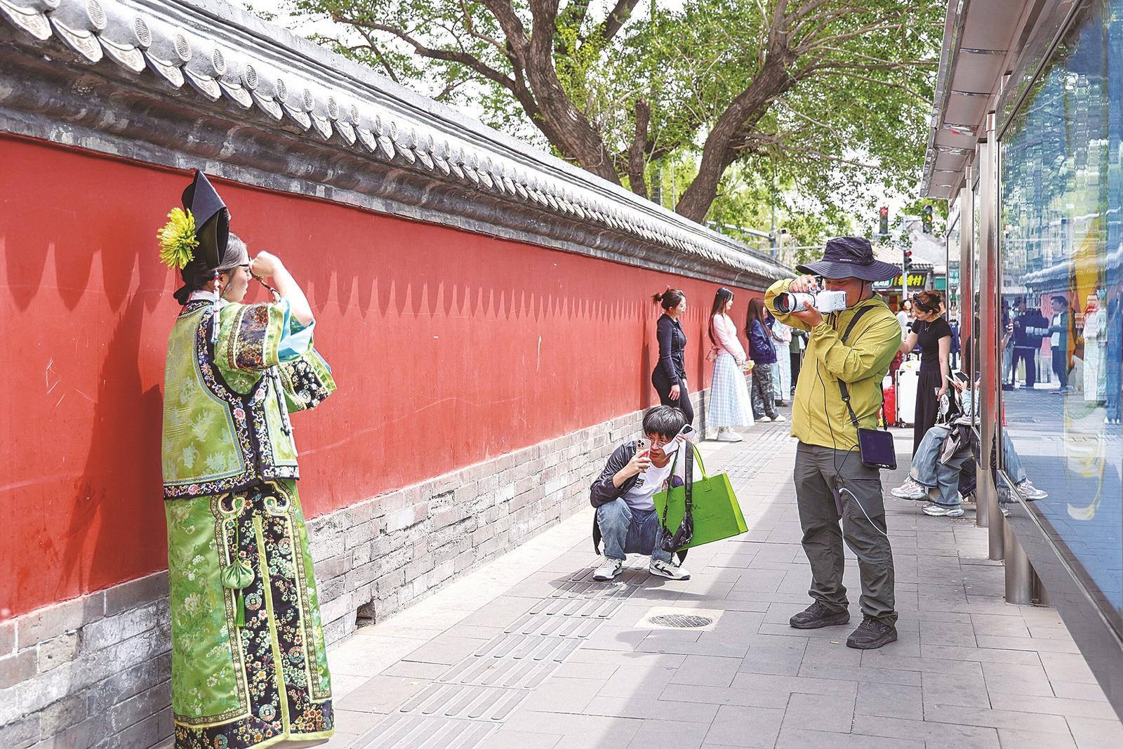 　　左图：正在鼓楼红墙前旅拍的游客 右图：正在旅拍店做妆造的游客 本报记者 曹雪文 摄