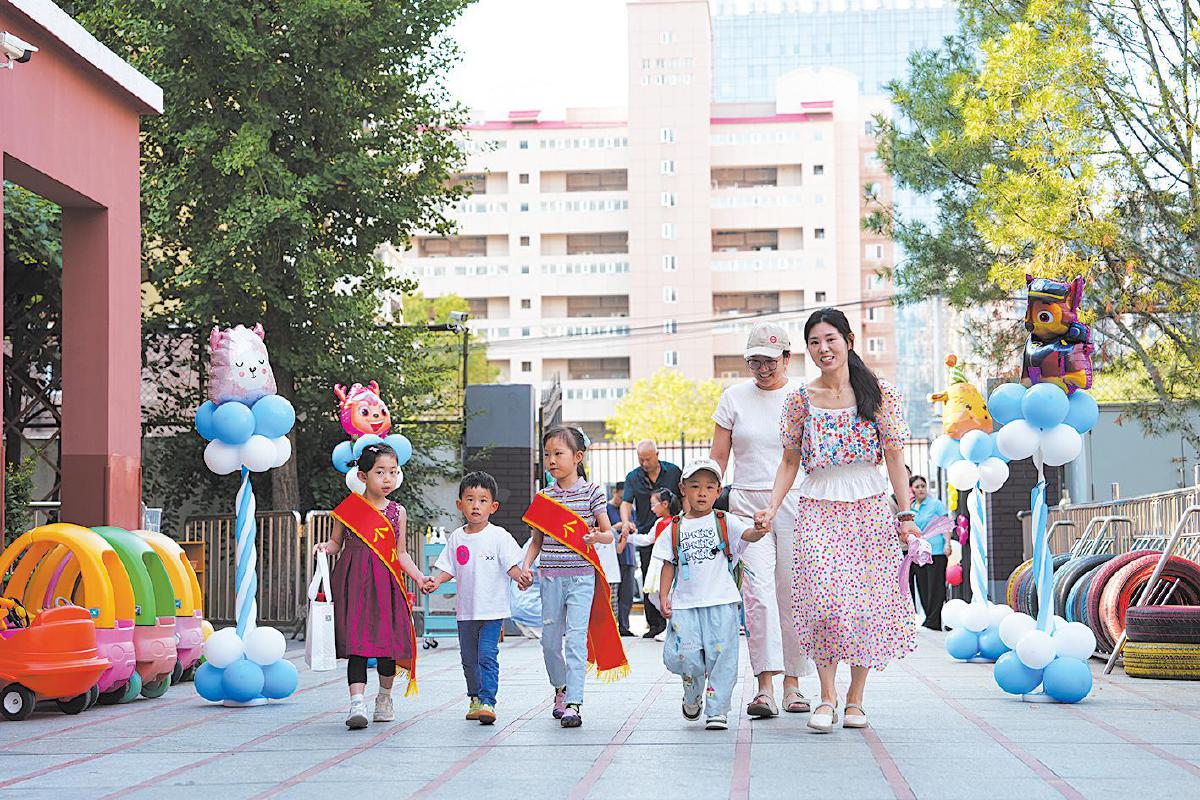 9月2日，九龙幼儿园，幼儿园老师和大班小朋友志愿者一起迎接托班幼儿入园。 北京教育融媒体中心供图