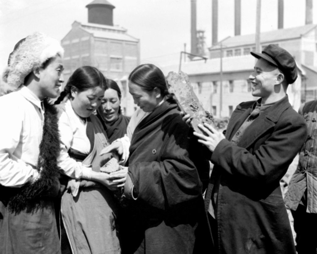 1950年4月2日，西北各民族青年、婦女參觀團參觀北京石景山鋼鐵廠。圖為代表們觀看生產的鐵錠。新華社發