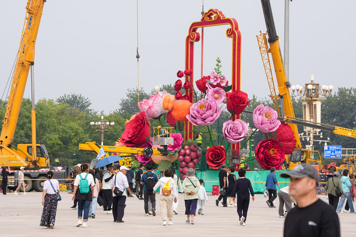 9月18日，施工人员在天安门广场布置花篮。新华社记者 鞠焕宗 摄