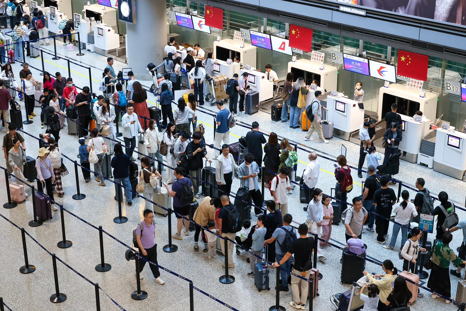 ▲10月1日，旅客在上海虹桥机场办理值机牌和行李托运 图据视觉中国