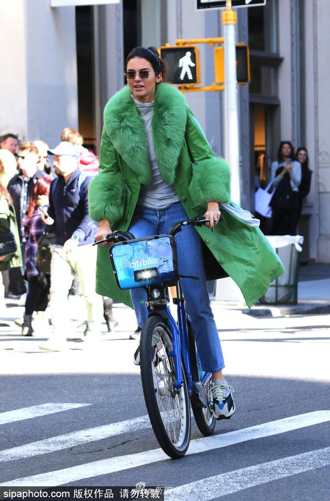 詹娜穿绿色皮草大衣街头骑单车