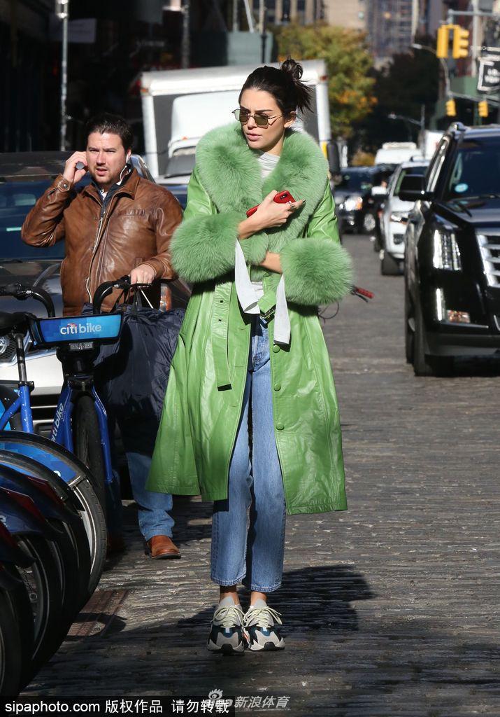 詹娜穿绿色皮草大衣街头骑单车
