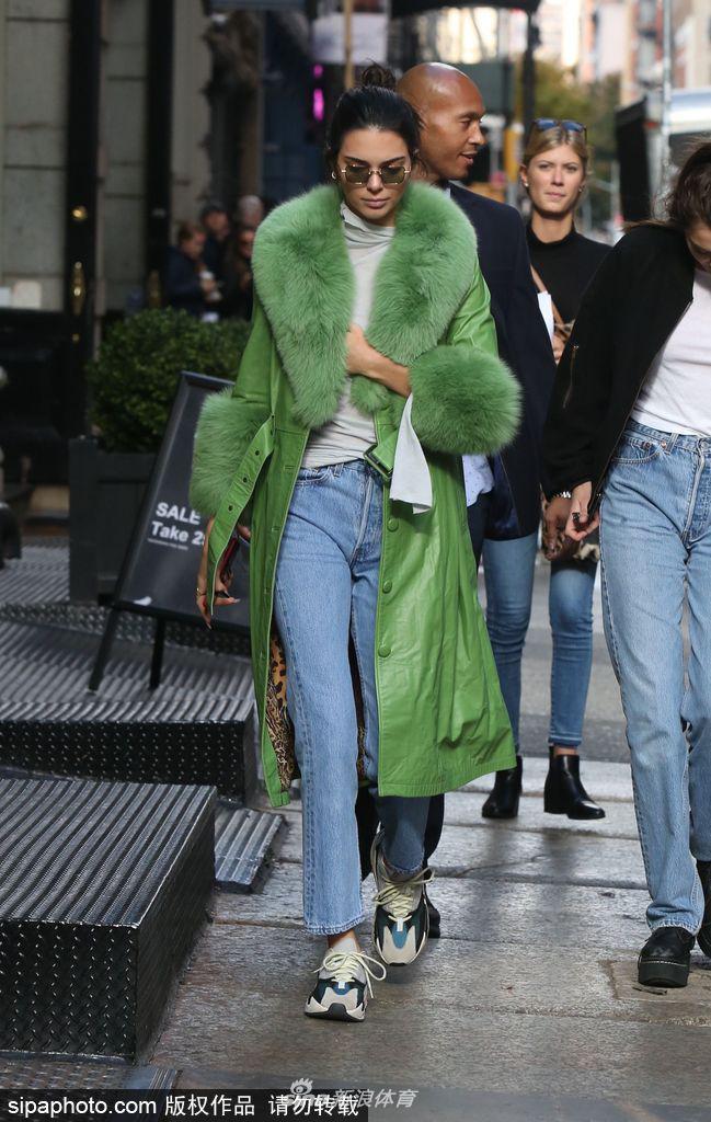 詹娜穿绿色皮草大衣街头骑单车