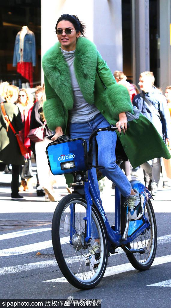詹娜穿绿色皮草大衣街头骑单车