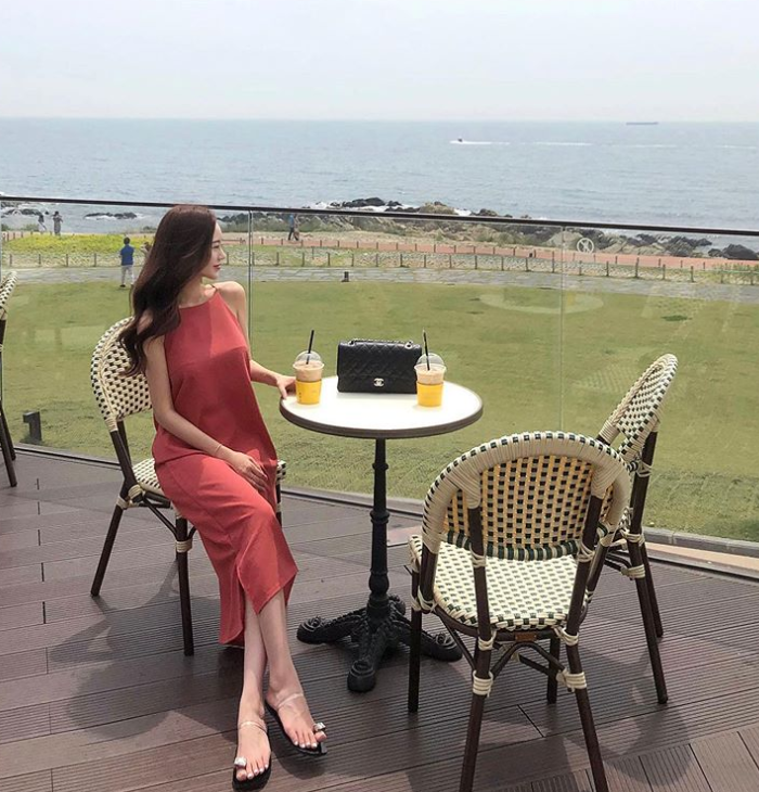 清新美女静坐喝茶遥望大海