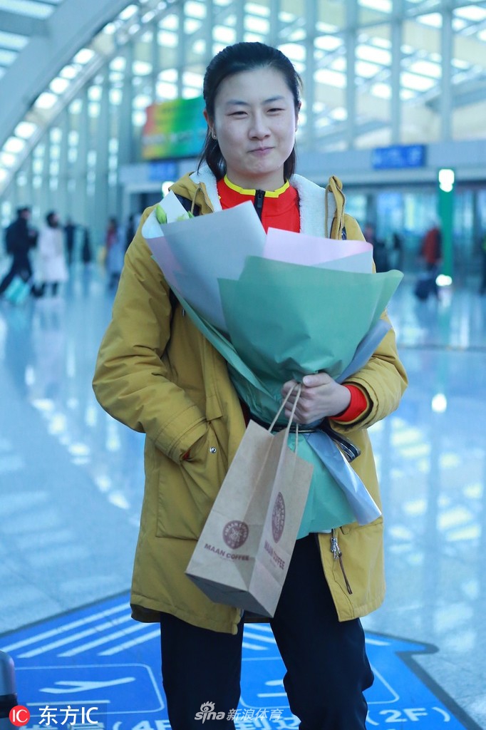 丁宁现身机场手捧鲜花