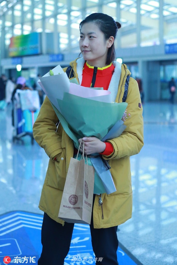 丁宁现身机场手捧鲜花