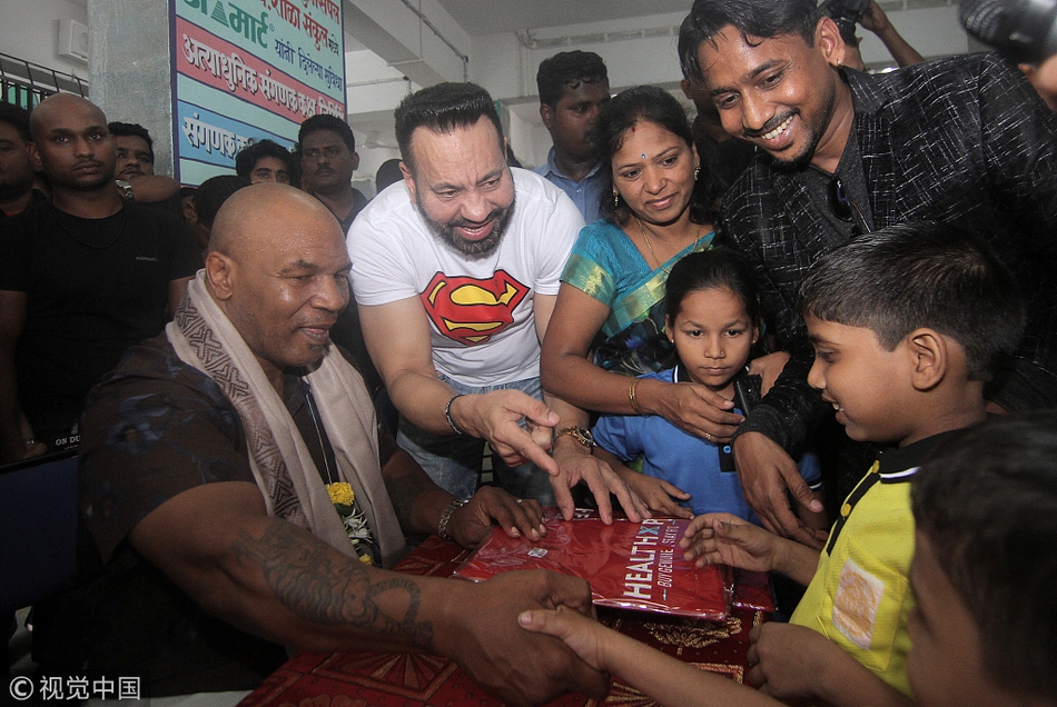 泰森现身孟买贫民窟学校献爱心 对镜头比V老拳王心不老