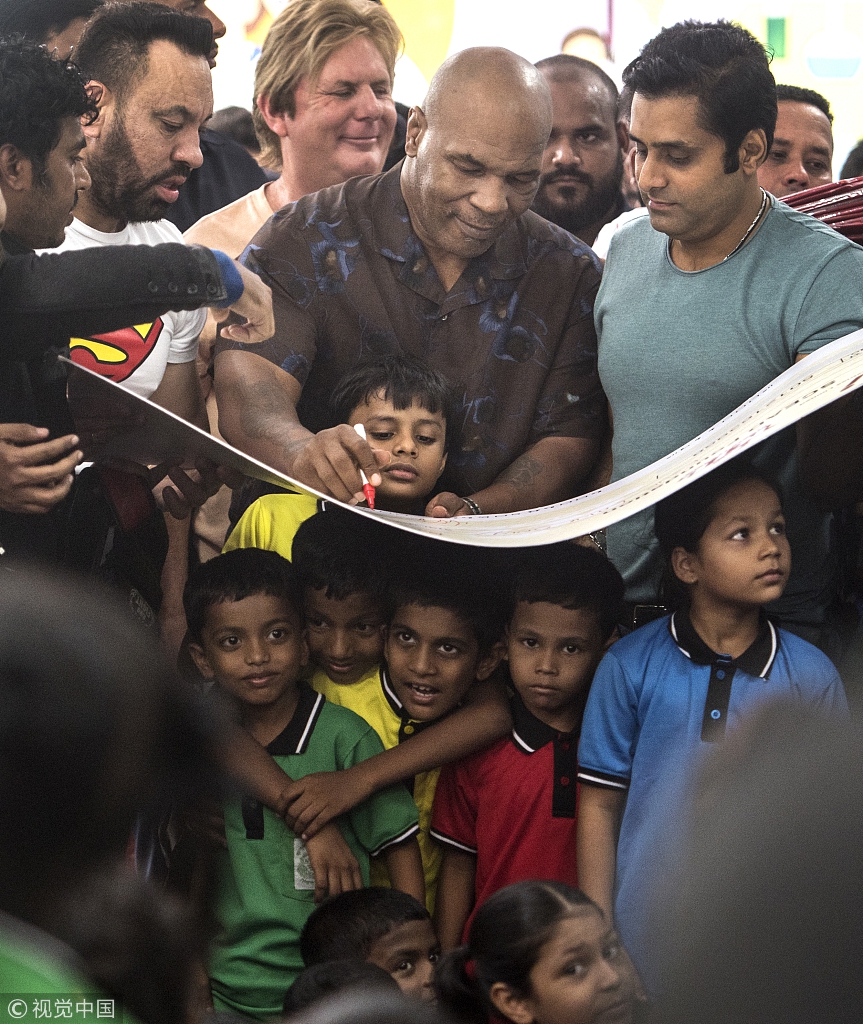 泰森现身孟买贫民窟学校献爱心 对镜头比V老拳王心不老