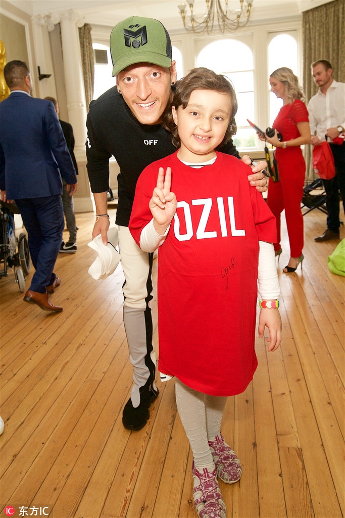 厄齐尔参加公益 与孩子打游戏