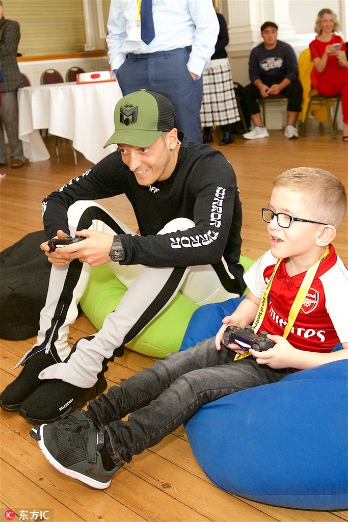 厄齐尔参加公益 与孩子打游戏