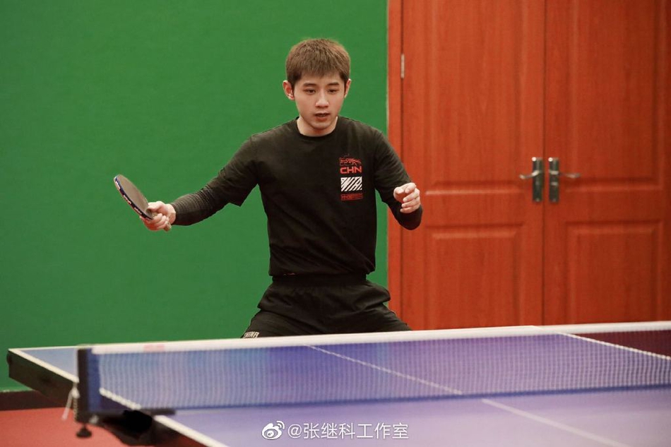 张继科身着黑色运动服打乒乓球