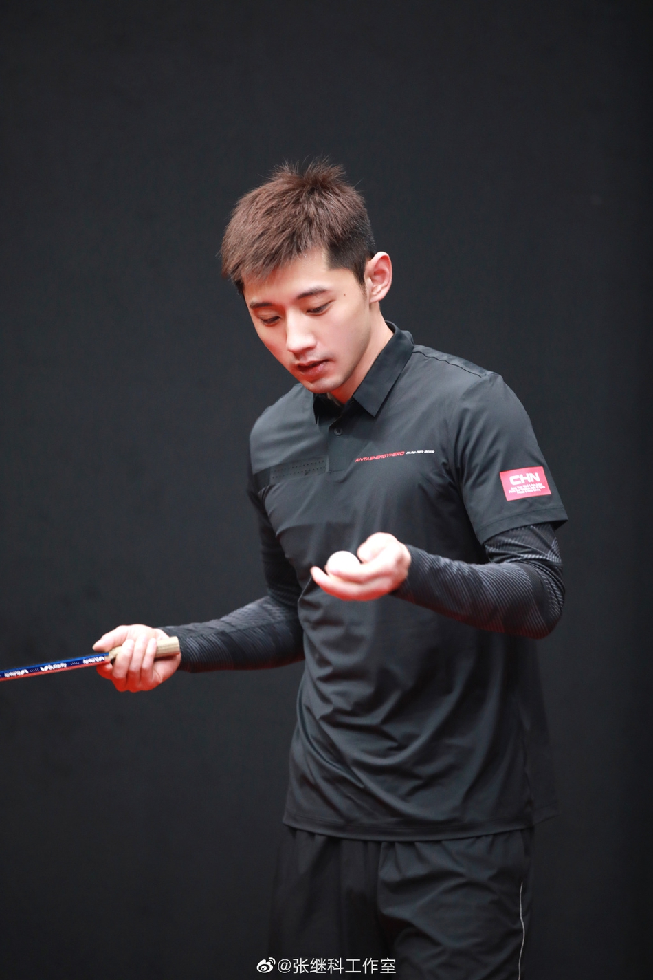 张继科身着黑色运动服打乒乓球