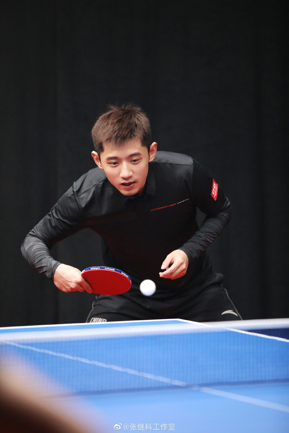 张继科身着黑色运动服打乒乓球