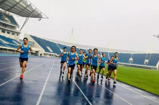 奥体中心魔幻的蓝色跑道上，队员们在大雨中追逐