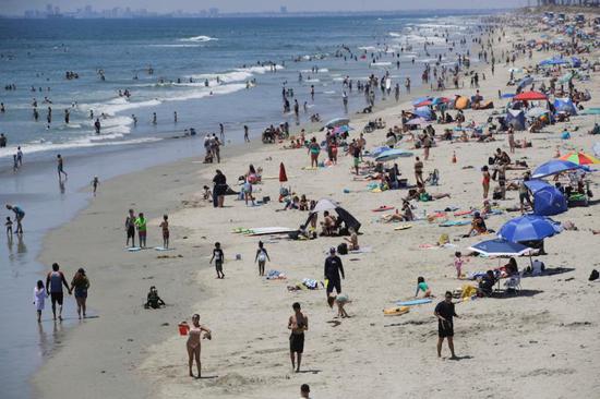 6月27日，人们在美国加利福尼亚州亨廷顿海滩游玩。