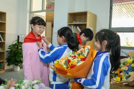 同学们为棋手配戴红围巾